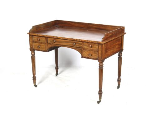 A late 19th century Gillows style mahogany writing desk. Having a gallery top with central drawer over a kneehole recess flan