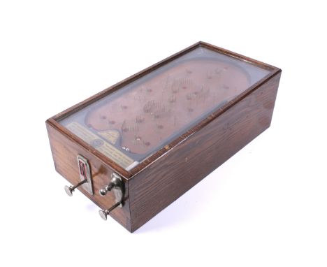 An early 20th century coin operated 'Advanced Pin Table' bagatelle. In an oak glass top case, spring mechanism and metal ball