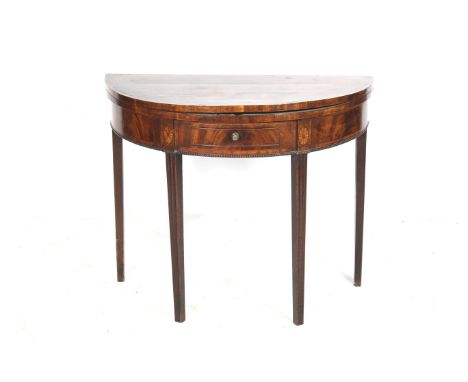 A Georgian mahogany demi lune card table with marquetry finish. Having a frieze drawer above beaded moulding, fold over top r