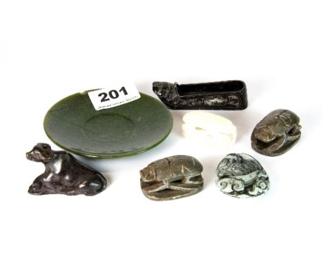 A small jade dish together with other carved stone items including Egyptian scarabs.