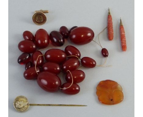 A Victorian pair of carved coral ear pendants, of tapering form, a red amber bead type necklace, unstrung, untested and unwar