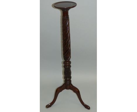 A mahogany torchiere stand, with moulded edged circular top, rope twist and acanthus carved turned stem and tripod base, 104c