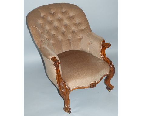 A Victorian walnut framed salon chair, with re-upholstered deep buttoned back and arms, serpentine seat and floral, leaf and 