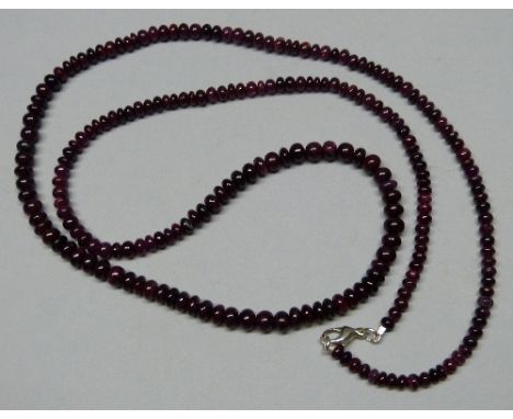 A single row ruby bead necklace, comprising slightly graduated beads, approximately 250cts in total, with a silver clasp, 81c