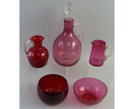A cranberry glass claret jug, of mallet shaped form with clear glass handle and stopper, 28cm high, a cranberry glass cream j