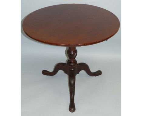 A 19th century mahogany tripod table, with plain circular tilt-top turned tapering stem with carved central knop and downswep