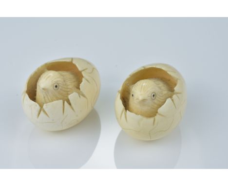 A pair of Japanese 19/20th century carved ivory netsuke of chicks hatching from eggs. (2)