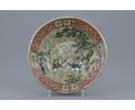 A Japanese celadon glazed pottery dish painted decoration of children playing. Makers signature in red under tree. 25cm diame