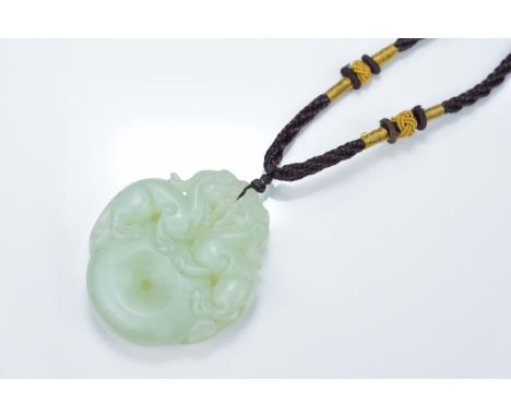 A Chinese carved jade Bi disc pendant surmounted with mythical beasts. 5cm length