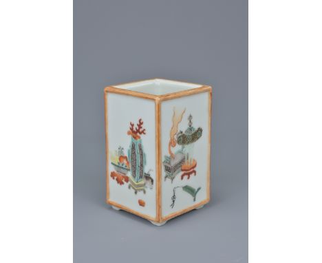 A Chinese late 19th century porcelain brush holder. Each side painted with Scholars objects. Inscription to base 'presenting 