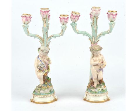 Pair of Dresden four light candelabra each with an allegorical figure of a cherub, one with a globe the other writing in a bo