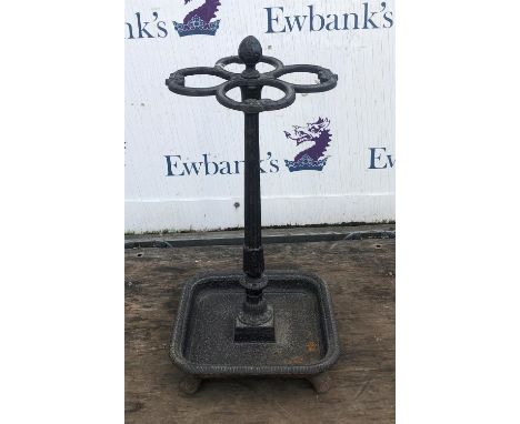Victorian cast iron stick stand, with four shaped apertures on a tapered stem with lotus leaf motifs, on a dished square base