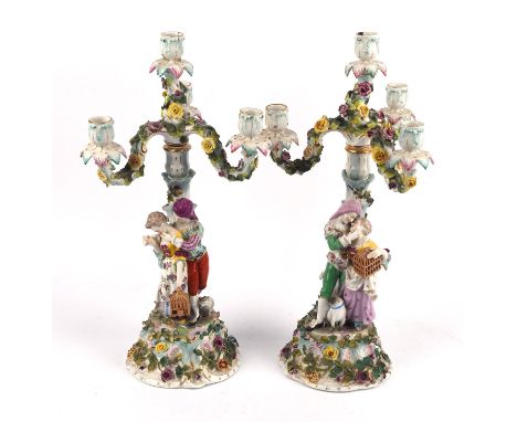 Pair of Sitzendorfer four light candelabra, each with a romantic couple carrying a bird cage and encrusted with flowers and l