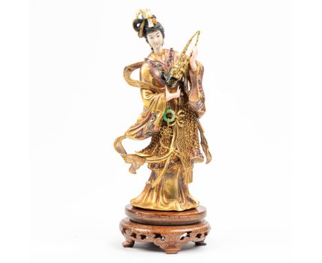 A statue of a musical figurine with a Sheng music instrument. The statue is marked 18k and made of 18kt gold. Decorated with 