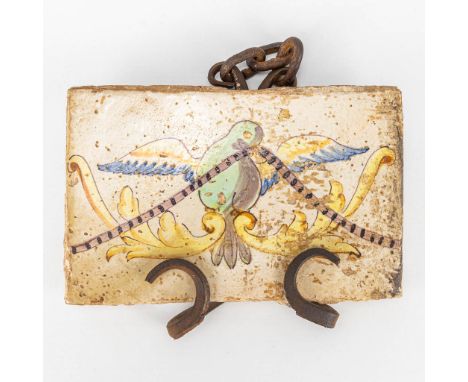 An antique tile with an image of a dove and mounted in a wrought iron frame. 18th century. (20 x 13 cm)