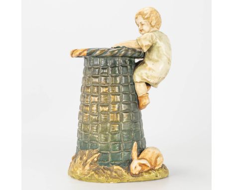 A ceramic statue of a child and rabbit by a large basket, marked Amphora, Austria. (15 x 19 x 31 cm)
