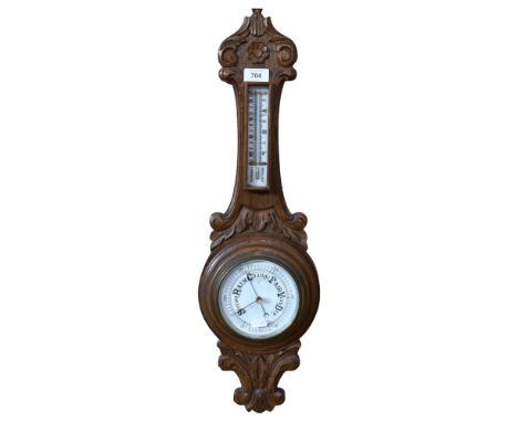 A carved oak-cased aneroid barometer with thermometer, 64cm 