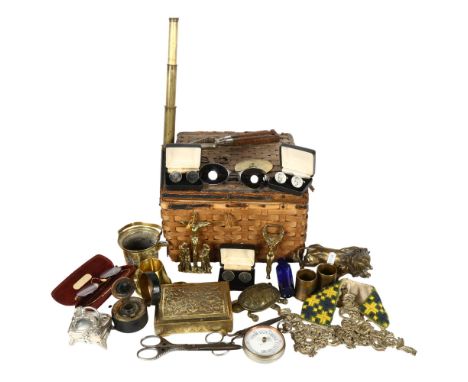 A Vintage wicker basket containing various items, including a mini brass telescope, a brass lion figurine, Vintage Gothic sew