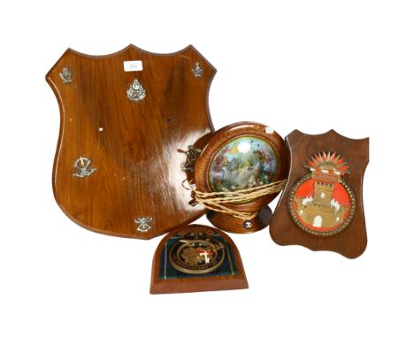 A group of wooden plaques with various Regimental/Nautical badges and crests, a maritime lamp in the shape of a ship's wheel,