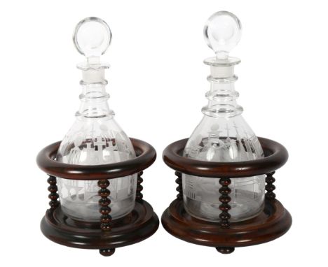A pair of Victorian Masonic decanters and stoppers, with etched design, 1 marked HAB, the other INRI, in turned wood stands, 