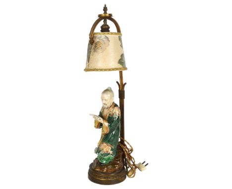 A Japanese 19th century porcelain figure of a man holding a book, mounted on a gilt-metal lamp stand, overall height 60cmGood