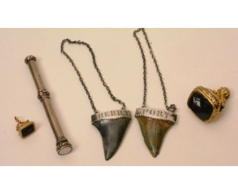 A yellow metal fob, with foliate decoration, together with another smaller yellow metal fob, two white metal and sharks tooth