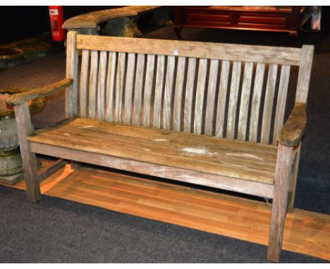 A wooden garden bench, with shaped arm rests, raised on block supports, 92cm high x 158cm wide x 63cm deep