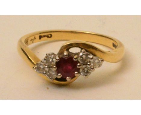 An 18ct gold ruby and diamond ring, the central round cut ruby surmounted by six round cut diamonds, three to either side, 0.