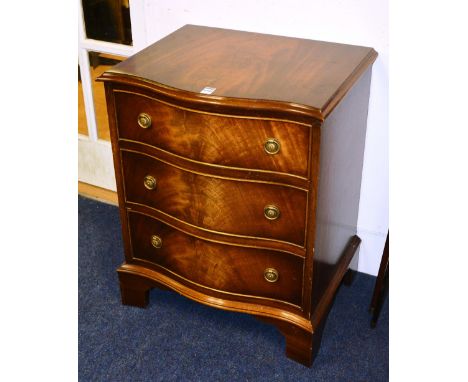 A serpentine shaped chest of drawers, of small form, with three graduated drawers, raised on bracket supports, 65cm high x 53