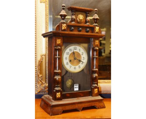 A gingerbread mantel clock, with a gilt dial and white enamel chapter ring, decorated with lion mask and foliate finials, 48c
