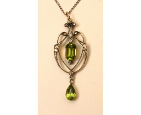 A yellow metal peridot and diamond pendant, the central emerald cut peridot drop (approx. 1.5ct) flanked by two brilliant cut