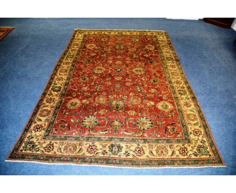 A Persian Tabriz carpet, with allover foliate design over red ground and triple border, 340 x 230cm