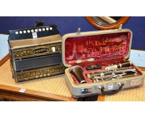 A Hohner squeeze box, ebonised with gilt floral decoration, 25cm high x 28cm wide, together with a clarinet in case (2) CONDI