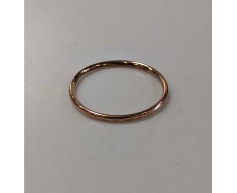 An arm bangle stamped '9ct', weight 9.5g