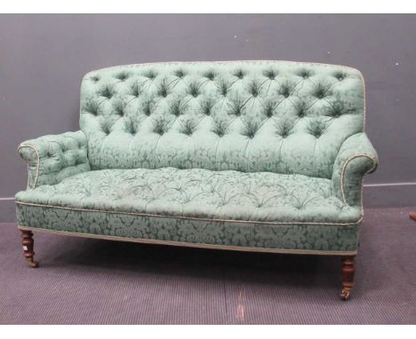 A late Victorian button back sofa on turned front legs and upholstered in green floral fabric80 x 165 x 65Structurally firmSo