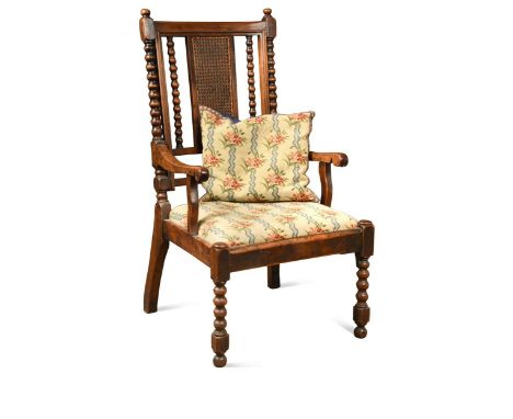 A provincial yew wood armchair, 19th century, the high rectangular back with caned panel flanked by bobbin turned supports ab
