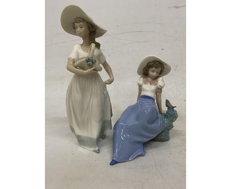 TWO NAO FIGURINES ONE OF A GIRL SAT ON A ROCK LISTENDING TO A BIRD AND A GIRL HOLDING A BASKET