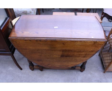 AN OAK OVAL GATE-LEG DINING TABLE ON TURNED LEGS, 60" X 42" OPENED