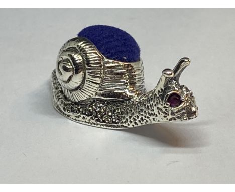 A MARKED SILVER SNAIL PIN CUSHION WITH RED JEWEL EYES