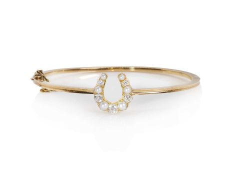 An Edwardian diamond and split pearl hinged bangle, the central horseshoe motif with graduated split pearls and old cut diamo