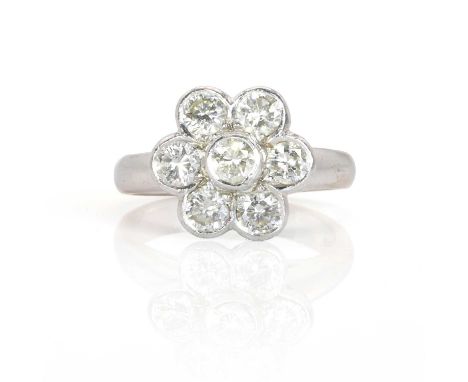 An 18ct white gold diamond daisy cluster ring,  with seven round brilliant cut diamonds rub set to an open gallery, to elevat