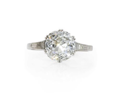 A large diamond single stone ring, c.1920,  the cushion shape old cut diamond in claw setting, to elevated shoulders further 