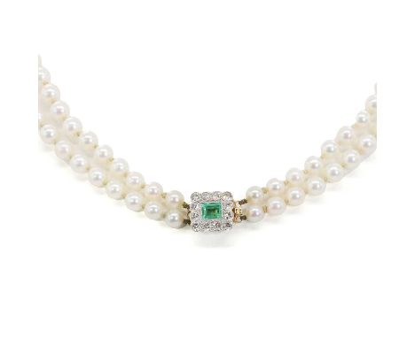 A graduated two row cultured pearl necklace with an emerald and diamond clasp, untested. One hundred and twenty one round cul
