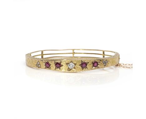A Victorian ruby, diamond and split pearl hinged bangle, with an old mine cut diamond flanked on each side by two graduated c