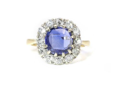 A Ceylon sapphire and diamond cluster ring,  the cushion shaped native cut sapphire encircled by a surround of Swiss cut, old