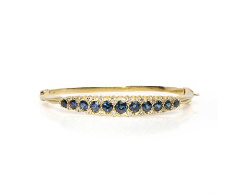 An 18ct gold sapphire and diamond hinged bangle, in Victorian style, set to the top half with a series of graduated circular 