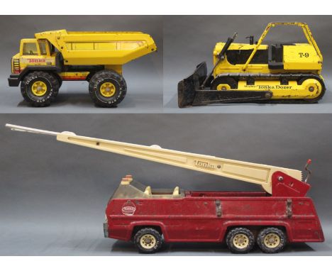 A group of three Tonka model vehicles, comprising a 1960's fire department fire truck with ladder, a T-9 mighty Tonka dozer, 