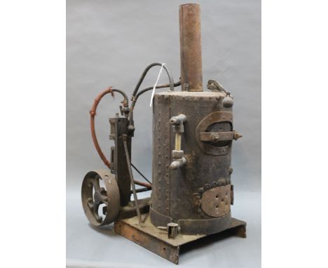 A late 19th/early 20th century steam engine, the cylindrical boiler with gauge and weighted pressure valve driving a pump to 
