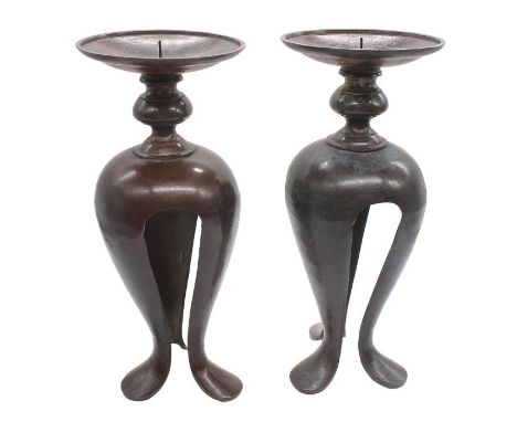 A pair of patinated bronze pricket Arts &amp; Crafts candlesticks