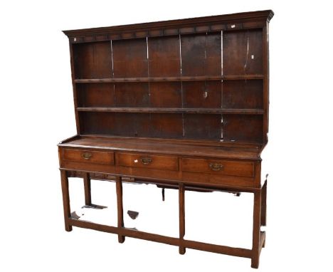 A George III solid oak English dresser on block legs with two shelf plate rack to the top above a three drawer base and an op